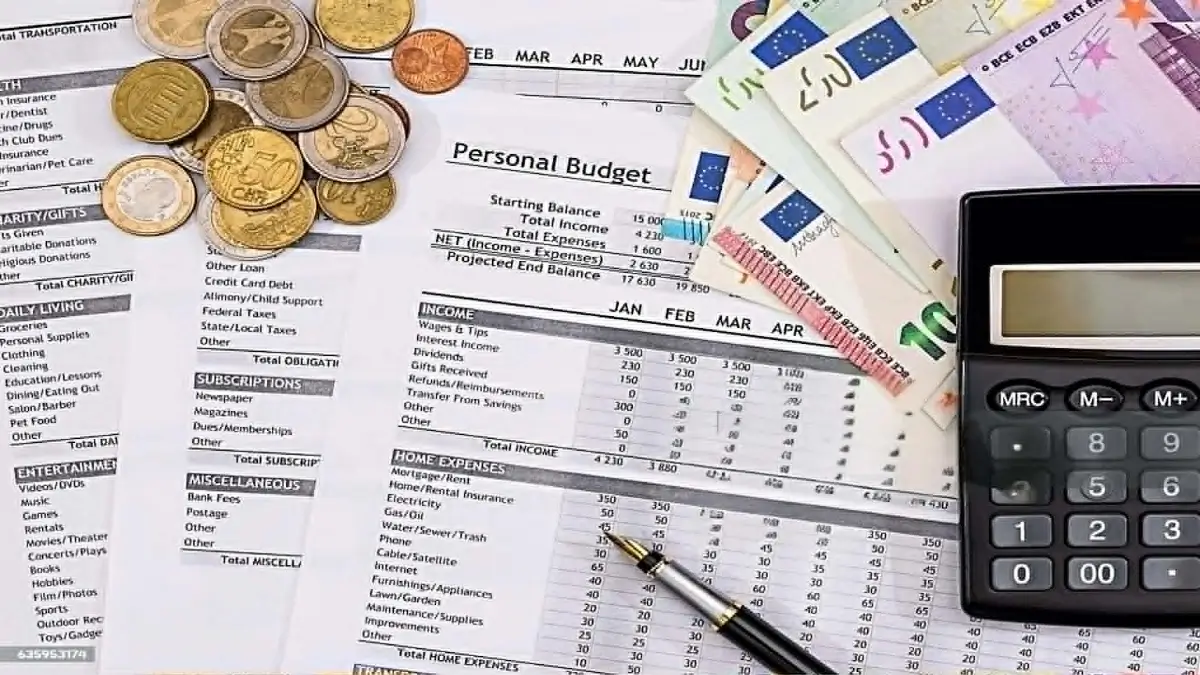 Calculatrice, pièces de monnaie et dossiers administratifs pour calculer l'augmentation CAF et RSA de juillet 2026.